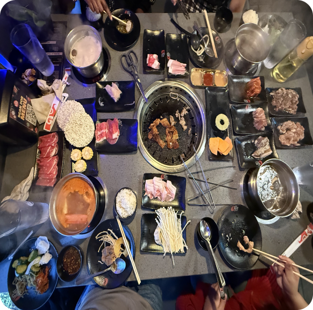 A table full of hot pot and Korean barbecue dishes