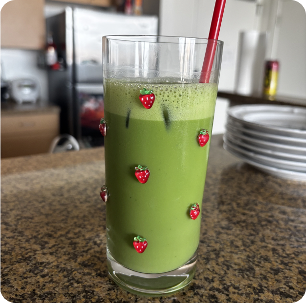 A glass of iced matcha decorated with strawberries