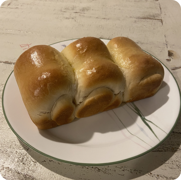 A golden loaf of homemade milk bread on a plate