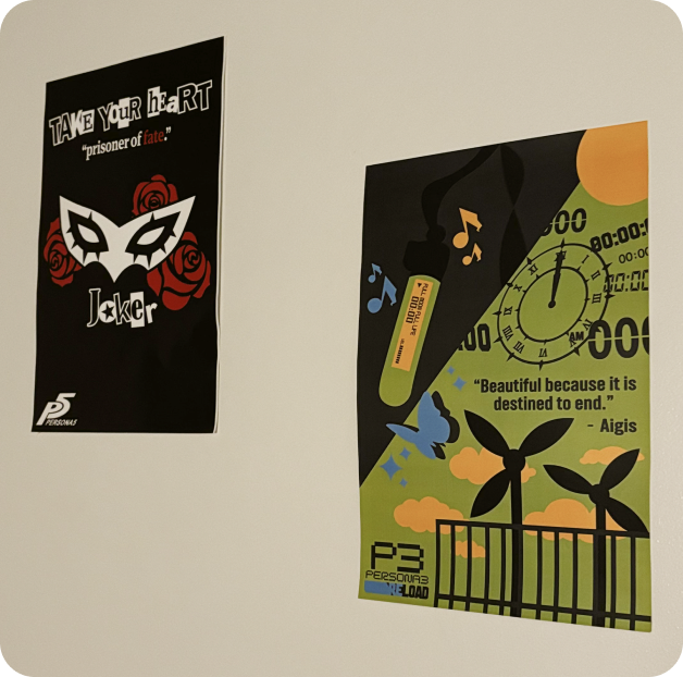 Two Persona fan posters pinned to a wall