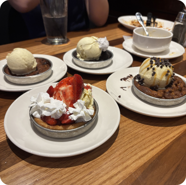 Plates of pizookies topped with ice cream and strawberries