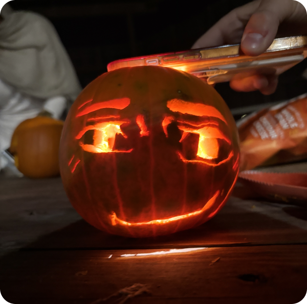 A glowing carved pumpkin with a smirking face